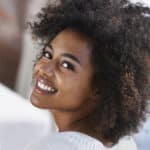 Amy’s Story – thumbnail Over the shoulder shot of a young woman using a laptop