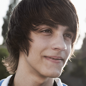 Teen boy with dark hair grinning