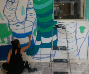 A resident of Eva's beginning to paint a tree.