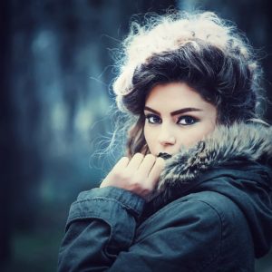 Young woman in winter coat looking at camera.