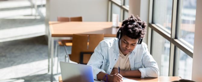 Black youth studying with headphones on