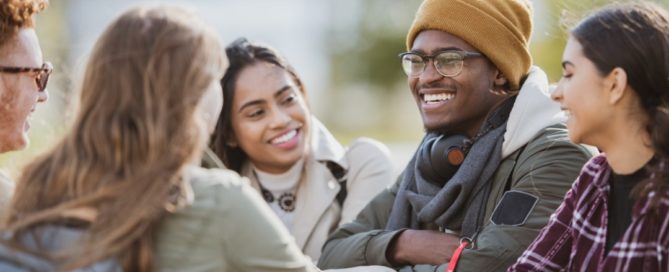 A group of youth hanging out around a table outdoors