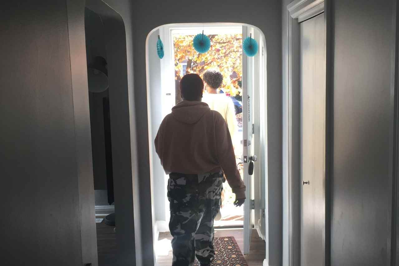 A shot of a young person leaving a house